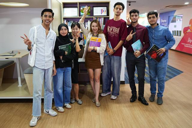 Students holding Cambright workbooks in a group photo