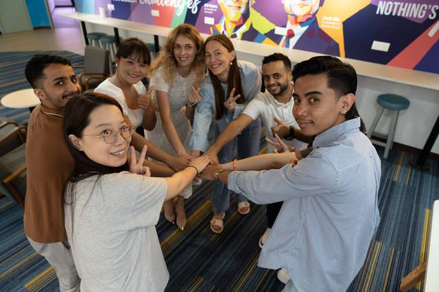 International students posing with joined hands at Cambright